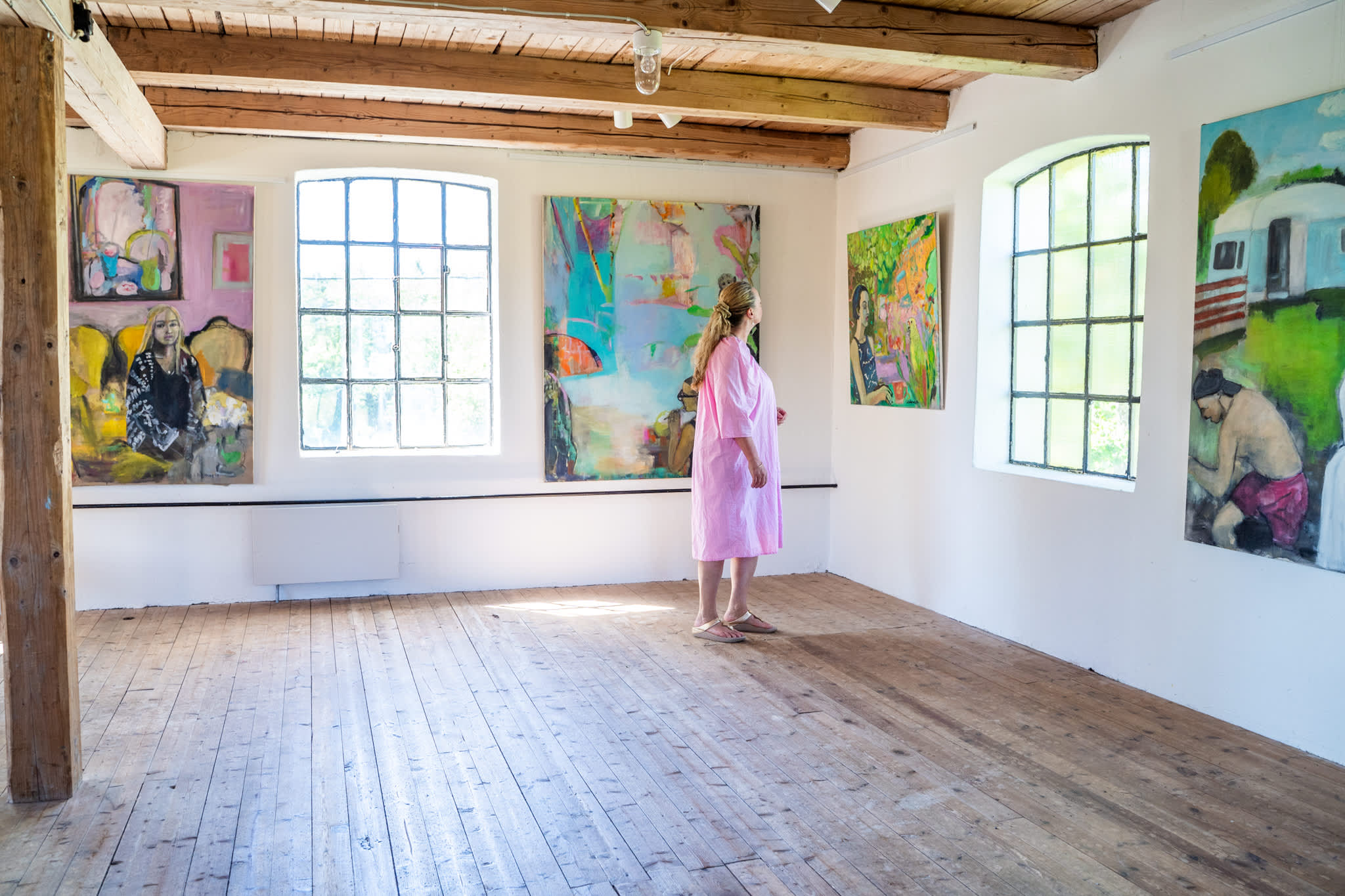 En dame kikker på bildene i galleri Strømsfoss