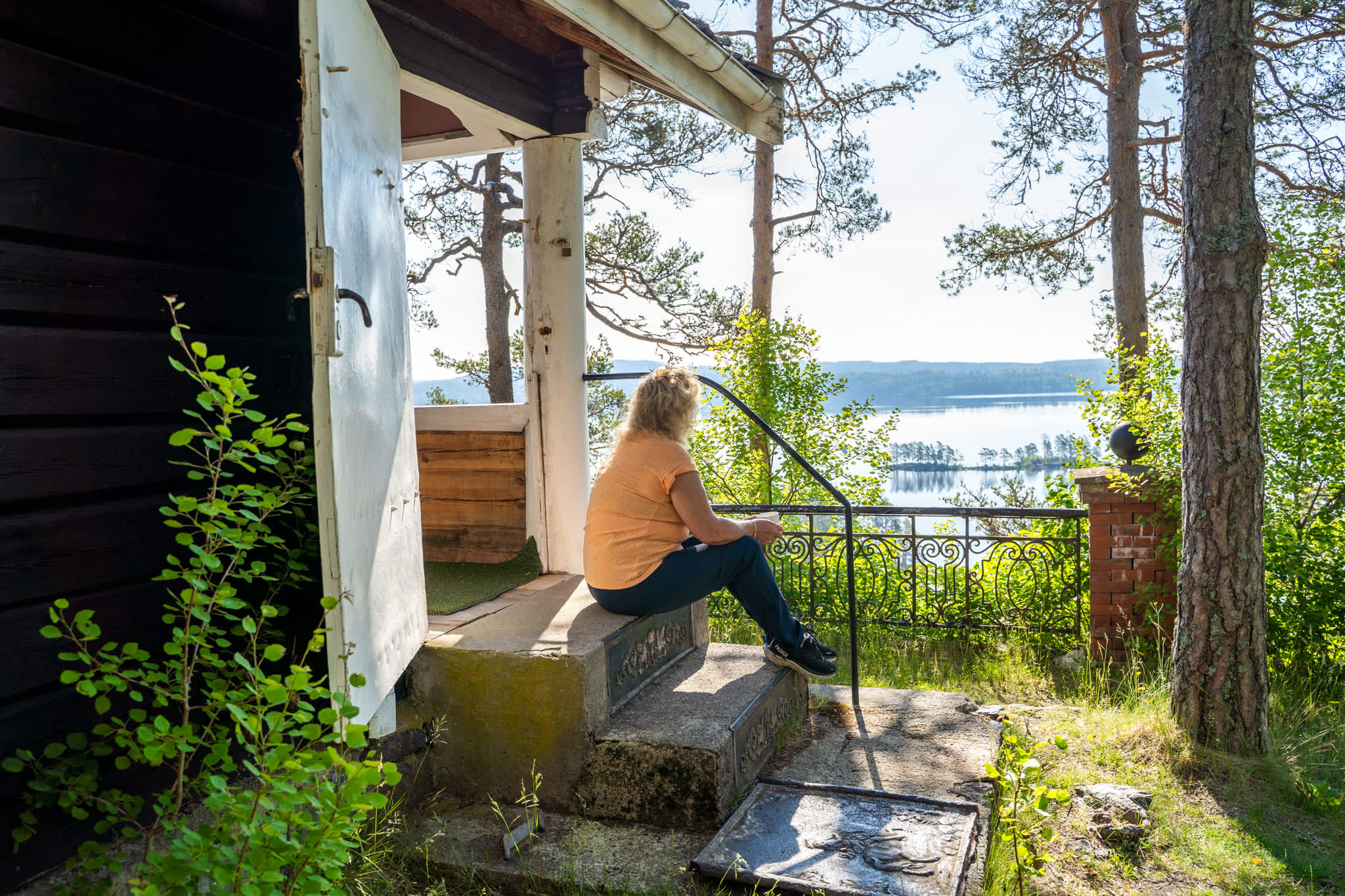 Dame som sitter på trappa og ser utover Haldenkanalen