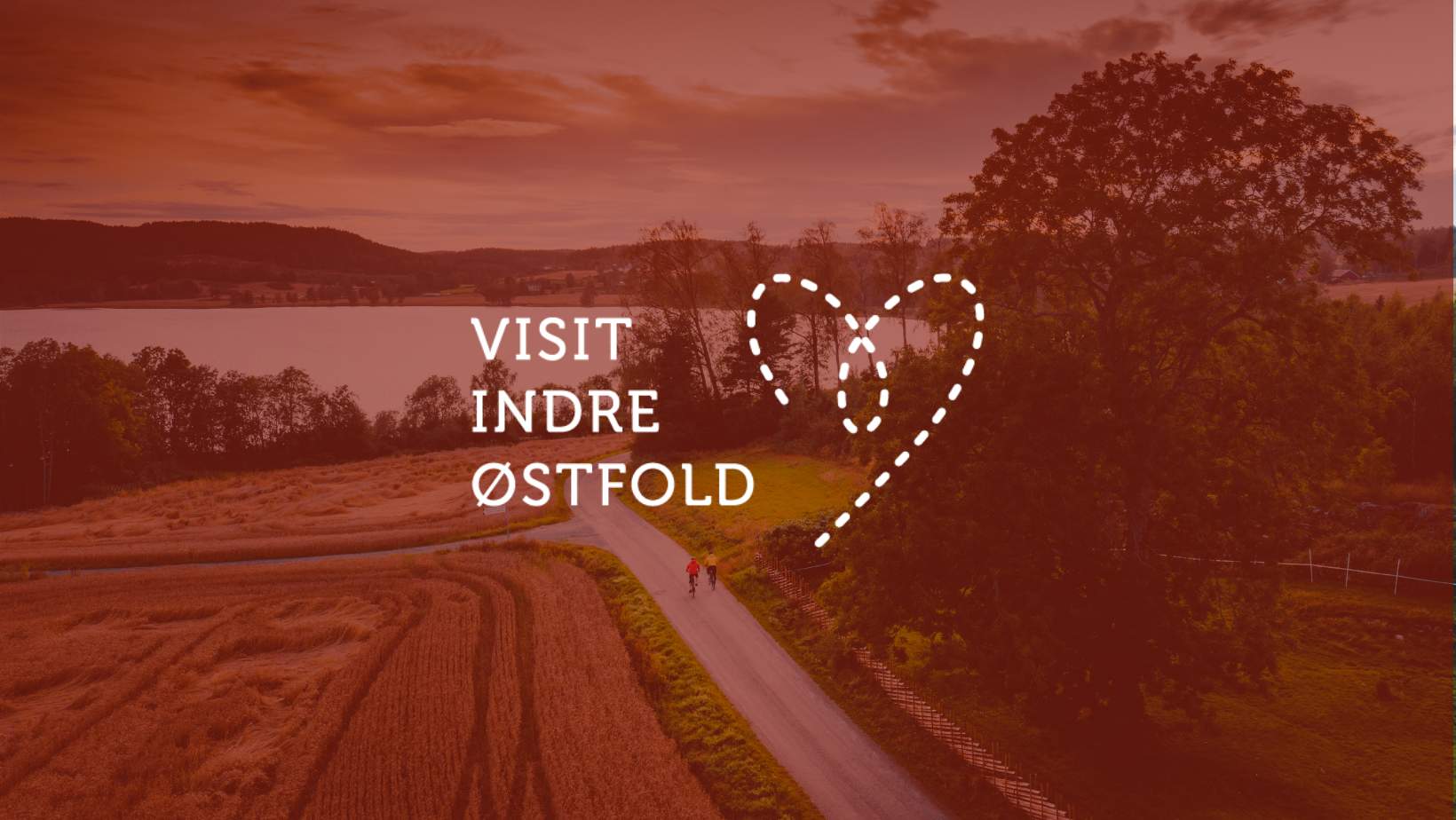 Visit Indre Østfold logo over ett sykkelbilde