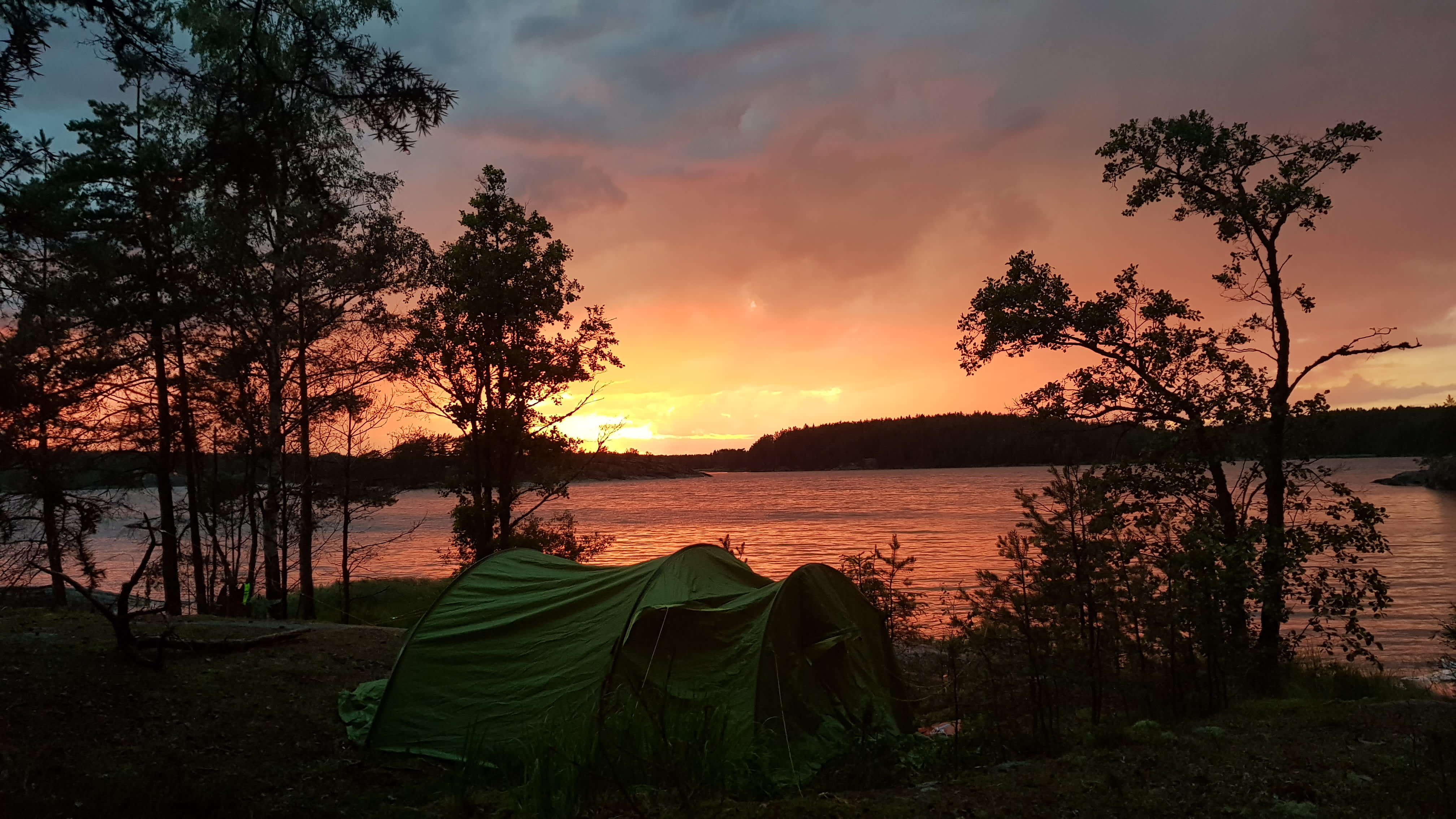 Telt i Vansjø med solnedgang