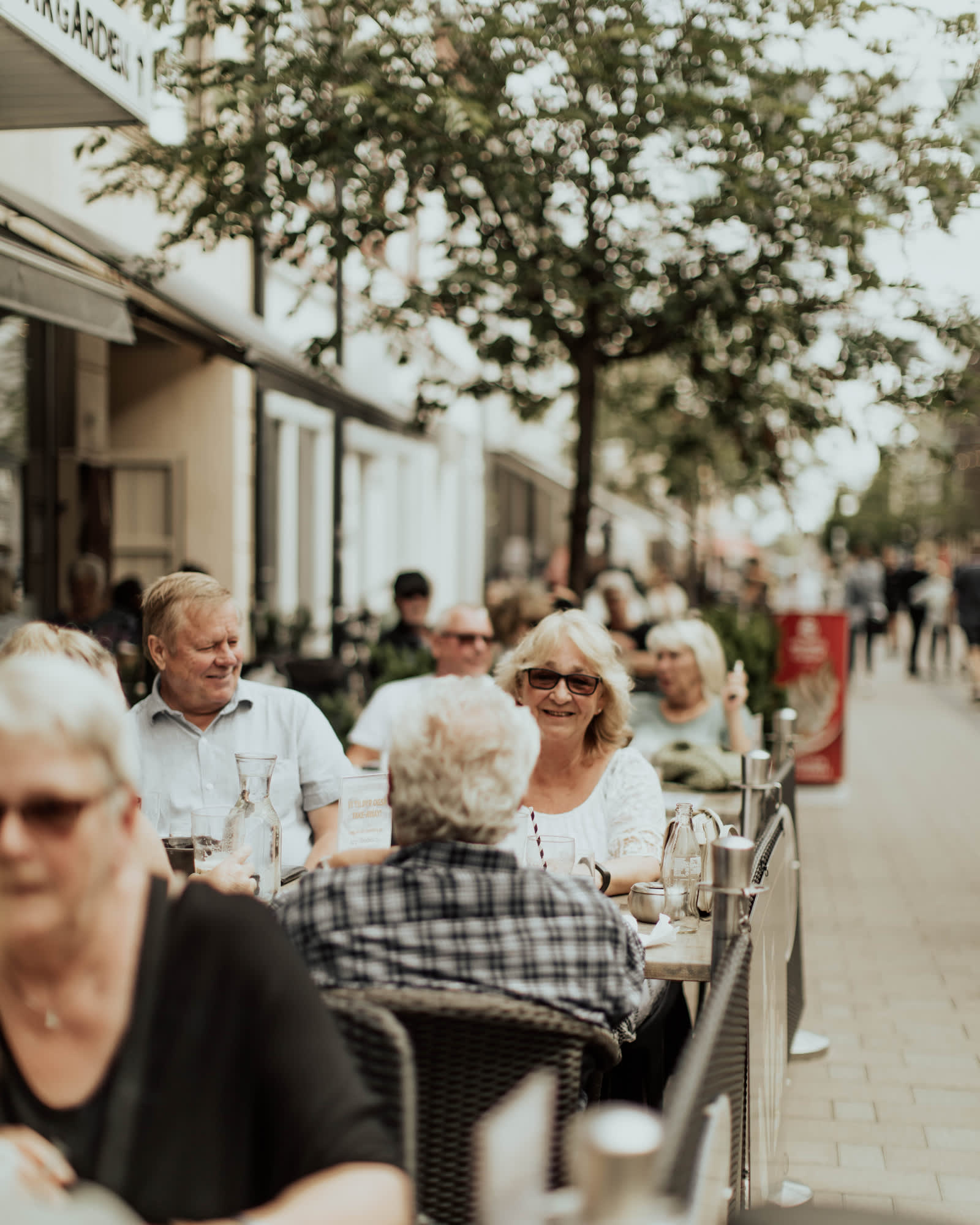 Glade mennesker på en uteservering i gågata i Sarpsborg. Foto