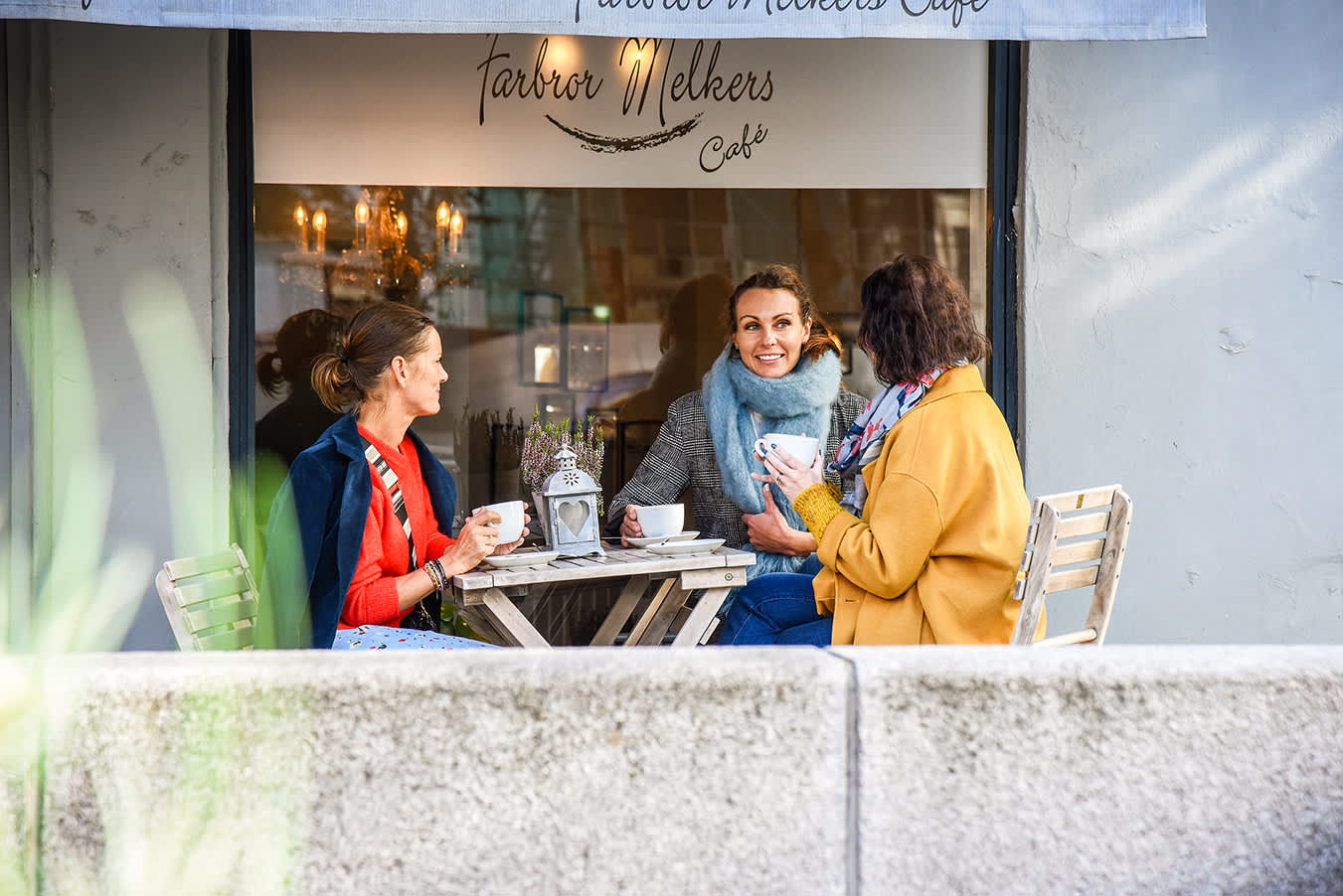 Venninnegjengen sitter sammen på kafé