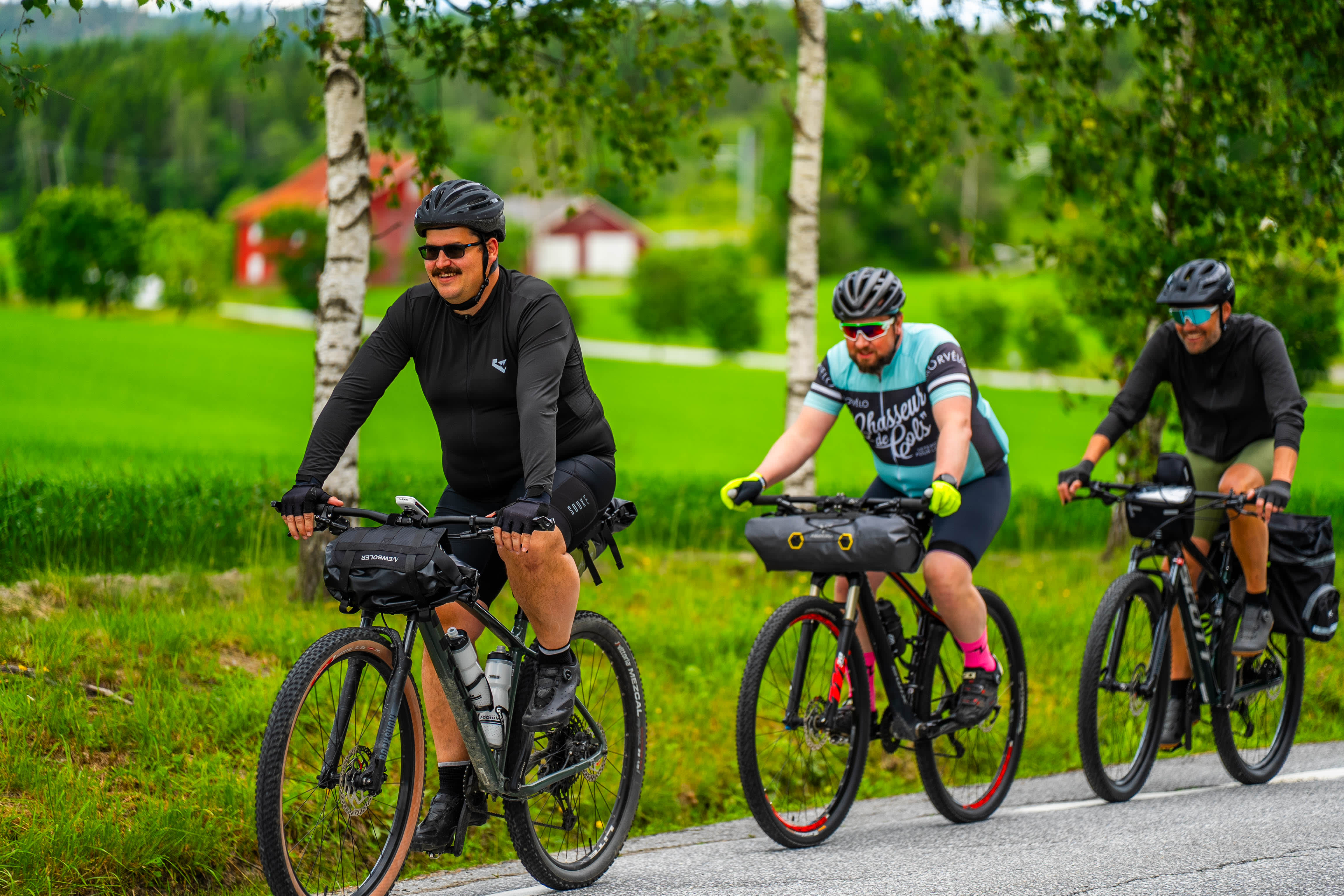 Syklister sykler gjennom frodig landskap