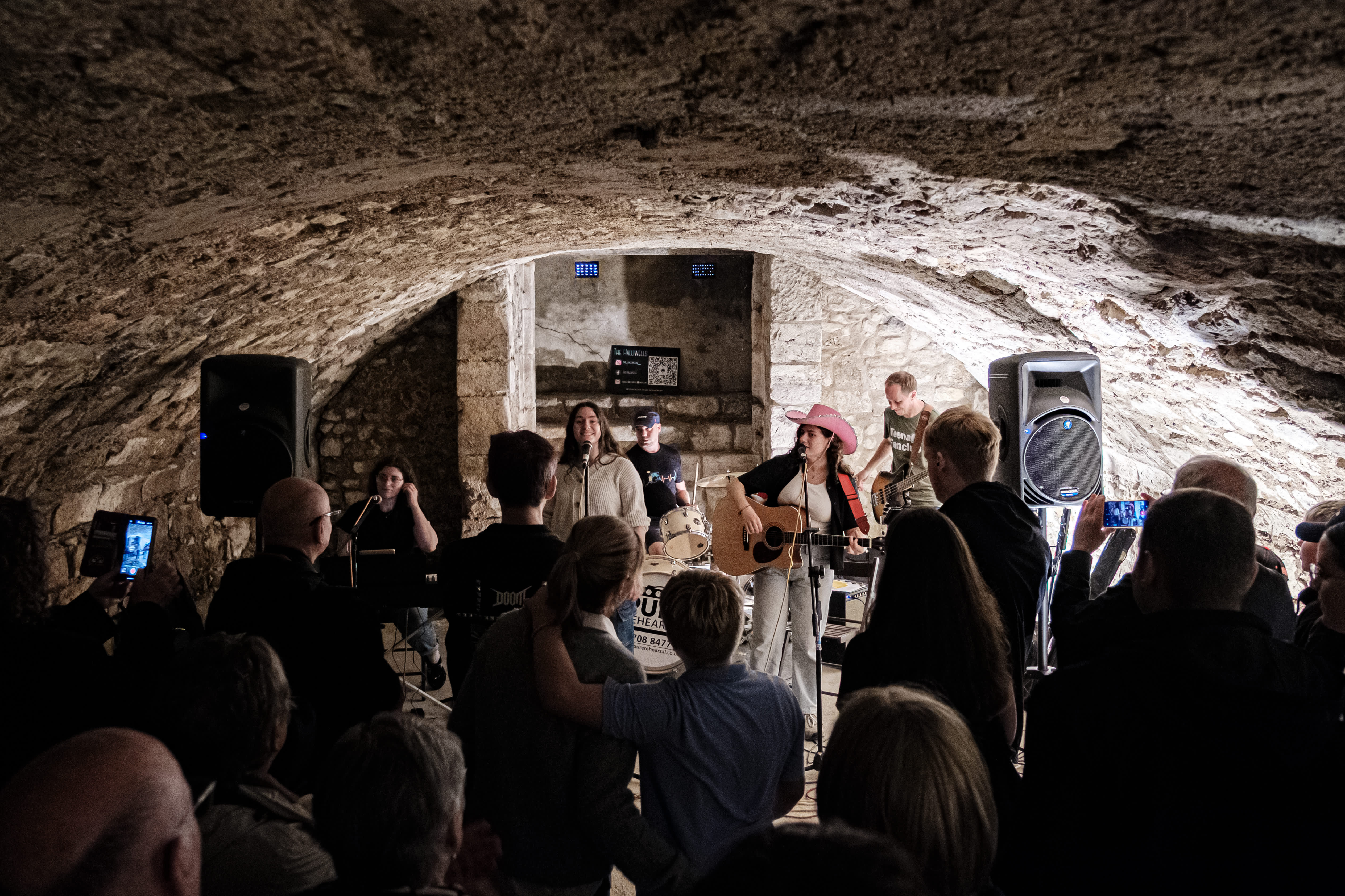 Music group playing an intimate performance at Music In The City in front of small crowd inside city vault