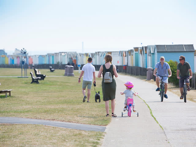 People out on a sunny day at Lancing Beach Green enjoying the leisure facilities with friends and family