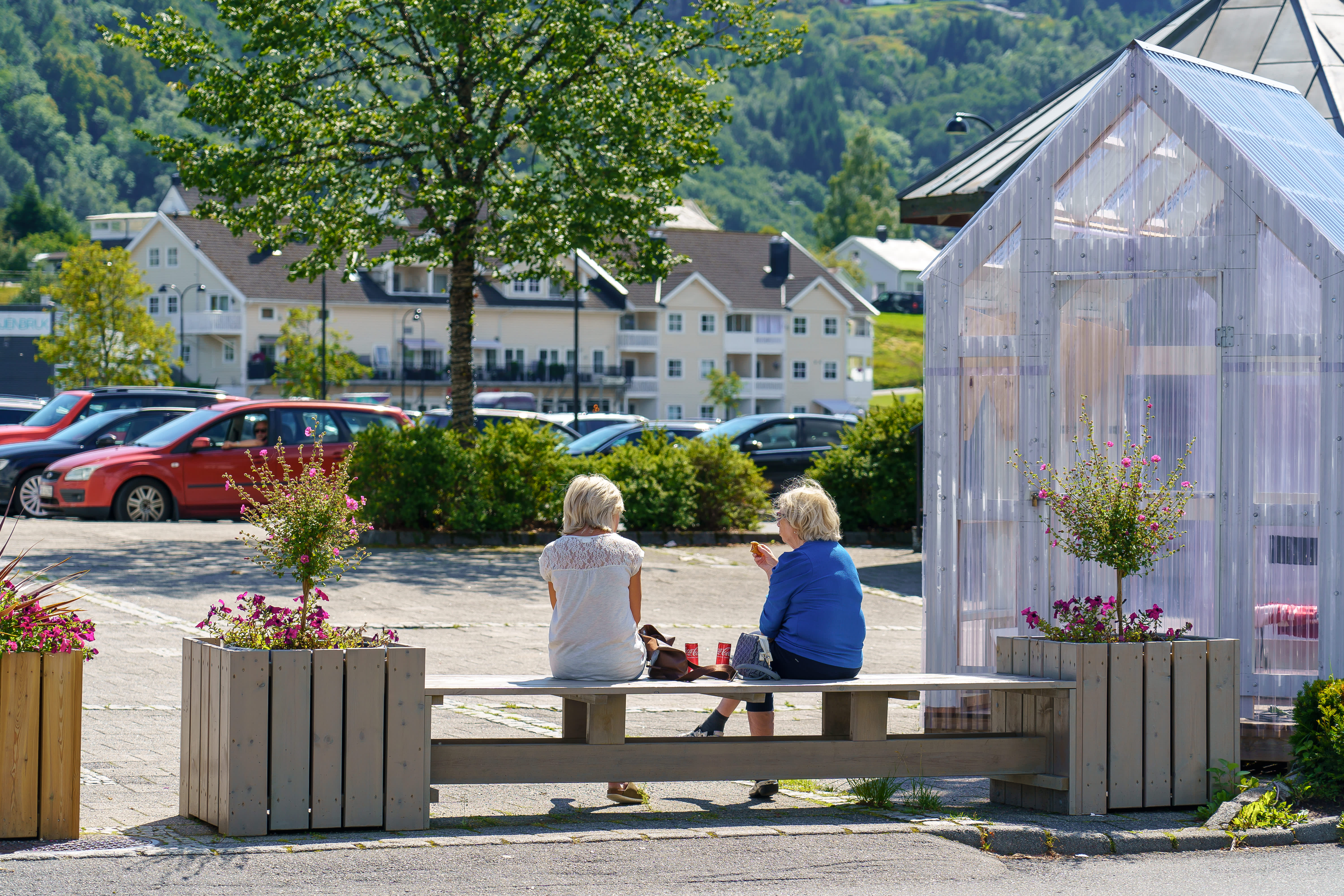 Spiser lunsj ved en benk i Liknes sentrum