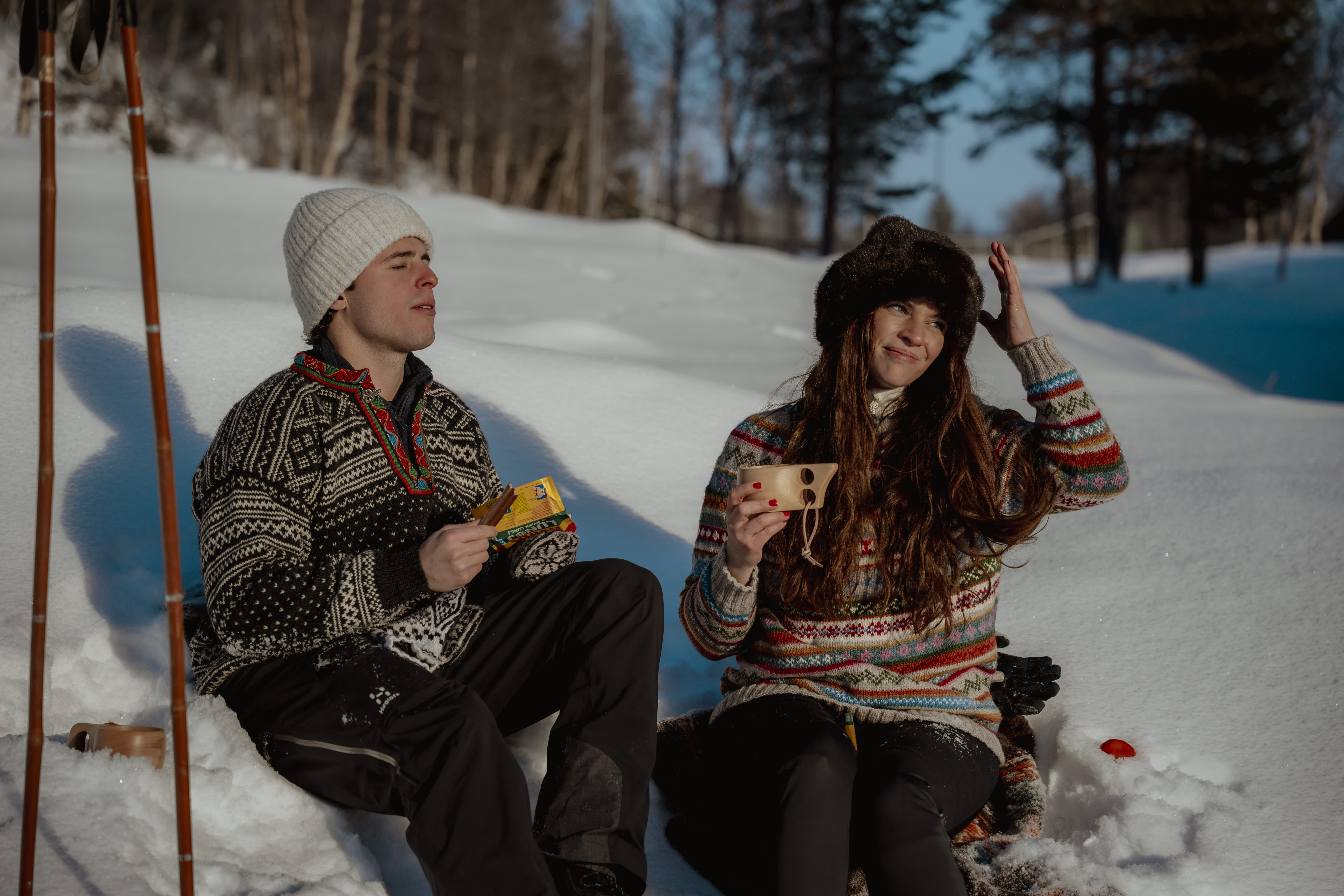 Par sitter i snøen og har sola i ansiktet
