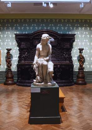 A sculpture of a woman in an ornate gallery