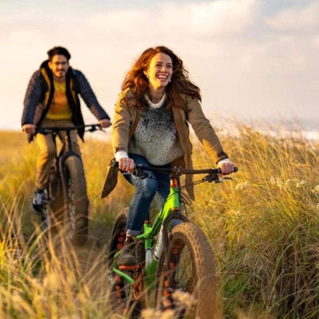 2 people on bikes in long grass