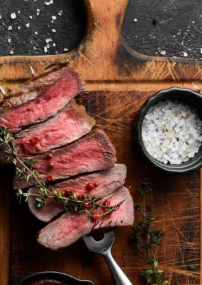 Rare steak on a skewer on a wooden chopping boars