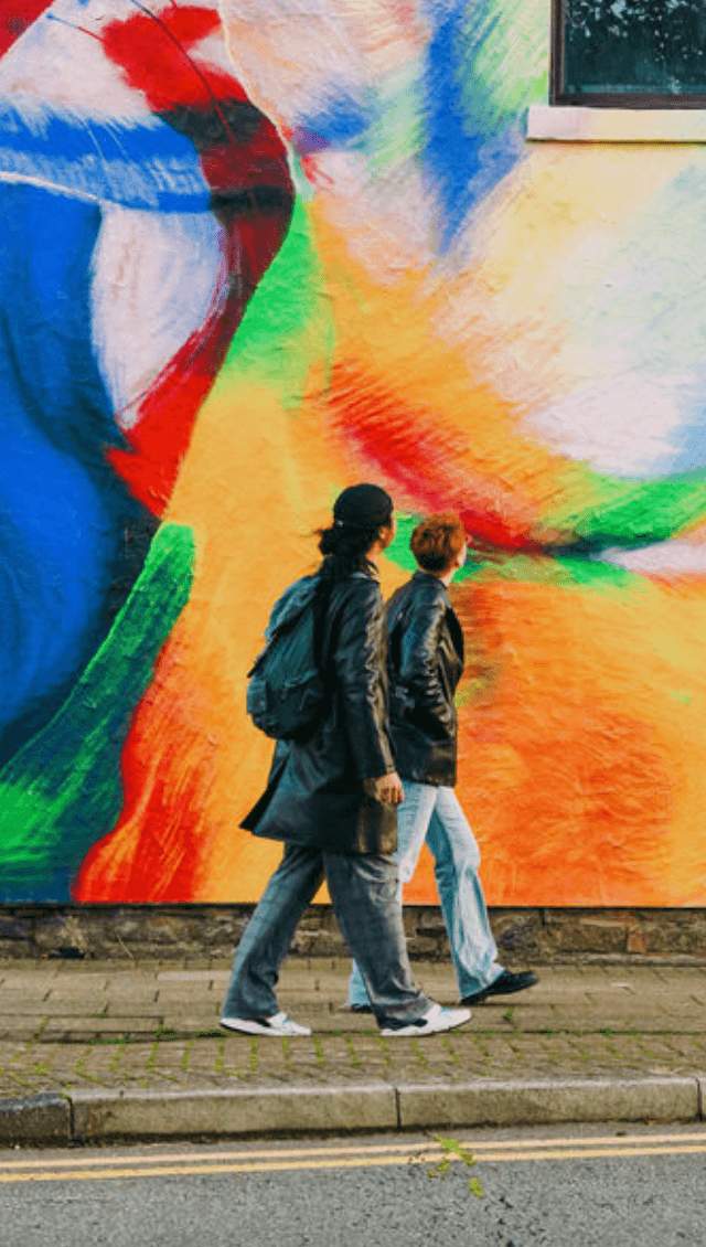 Two people looking at colourful street art