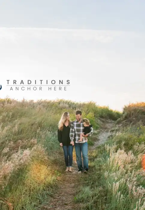 A family in holiday plaid clothing walks down the sand dunes