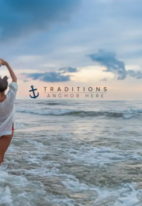Girl in waves of the ocean with the sunrising over the ocean. The traditions anchor here logo on the back.