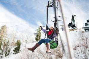 Woman sliding down zipline in winter at Utah Olympic Park
