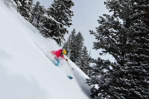 Woman skiing down steep powder field