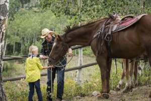 Girl Prepares to Ride a Horse