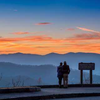 A couple enjoys a mountain vista on the Blue Ridge Parkway near Asheville, NC