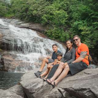A family enjoys a stunning waterfall in the Blue Ridge Mountains near Asheville, NC