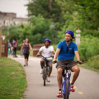 Two men riding bikes along the greenway in Asheville