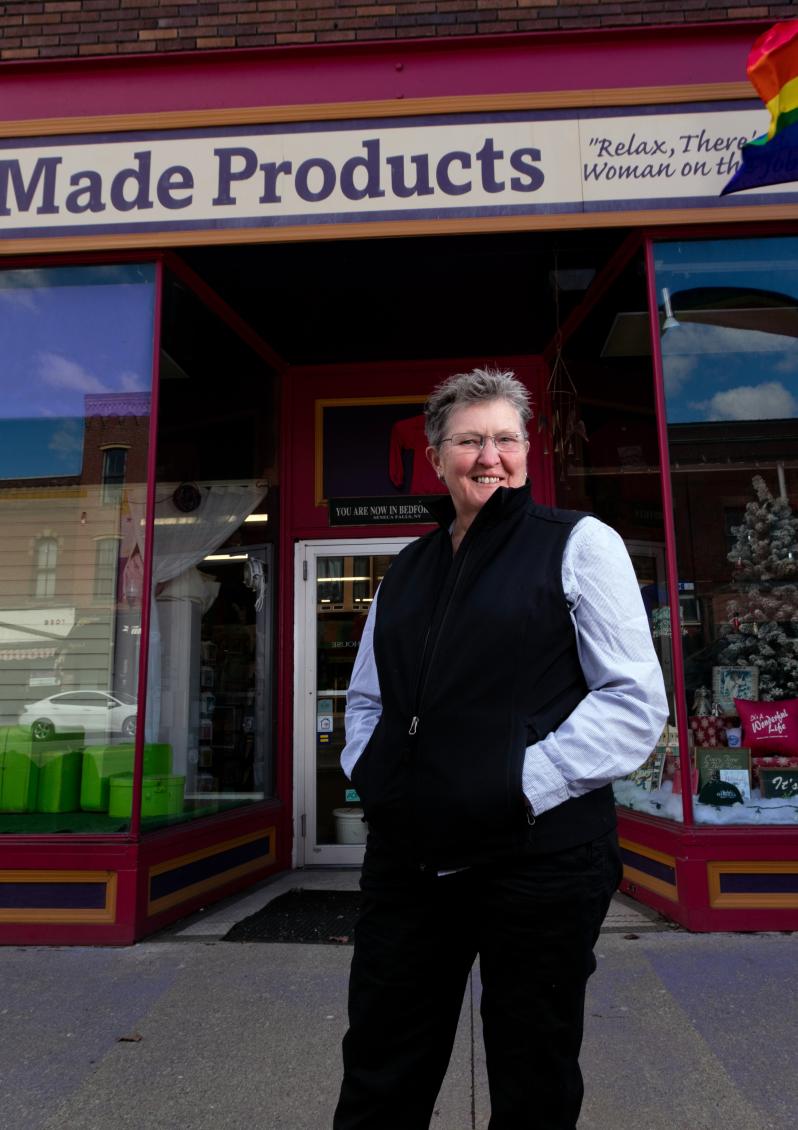 Outside of storefront with owner in foreground