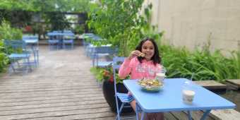 A child eating food on a patio