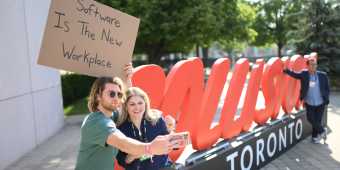 Seth Phillips from @dudewithasign, during day one of Collision 2022 with a 'Software is the new workplace' sign