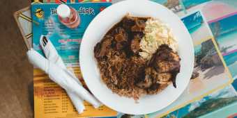 Plated dish atop a menu at The Real Jerk Restaurant in Toronto