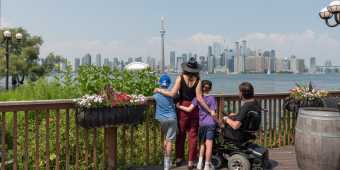 A family looks at the view of the Toronto skyline from Centre Island in summer