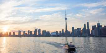 The Toronto skyline in the summer with a Tiki Taxi ferry on the water
