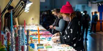 Vendor with products on a table at Toronto's One of a Kind Show