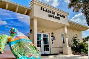 Exterior of the Flagler Beach Historical Museum with a sea turtle statue in the foreground.
