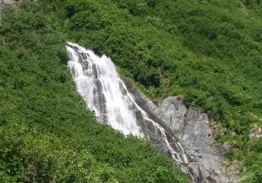 a waterfall on a lush mountain side