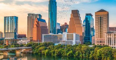 bats flying from the congress bridge in front of Austin skyline at sunset