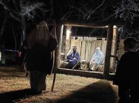 Two people are dressed as Mary and Joseph in a manger at the live nativity scene at A Country Christmas at Fulton Valley Farms