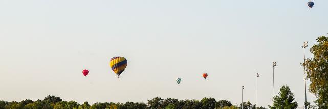 Several hot air balloons floating over Bloomington