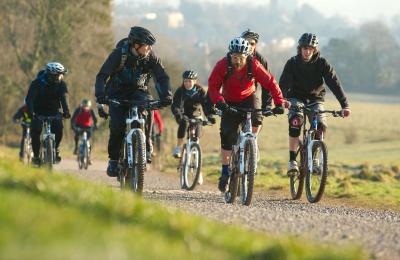 A group cycling on rented mountain bikes towards the off-road mountain biking trail at Ashton Court - credit Pedal Progression