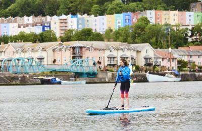 Person stand up paddleboarding in harbour