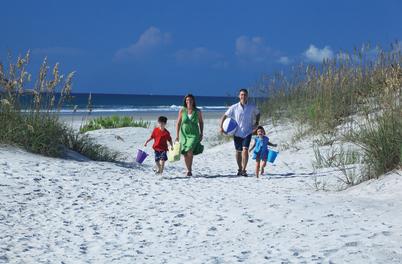 Family walking thru dunes at Wrightsville Beach