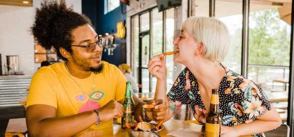 Couple sharing fries at downtown restaurant