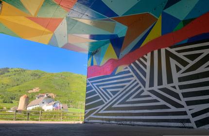 Artists mural in tunnel with the white barn in background