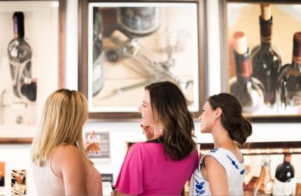Three women viewing art and talking to each other