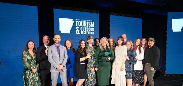 The Visit Bentonville staff poses for a photo with the Secretary of the Parks, Heritage, and Tourism, Director of Tourism, when accepting the award.