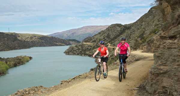 Two women cycling the Roxburgh Gorge Trail alongside Lake Roxburgh