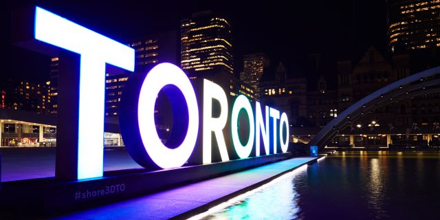 The Toronto Sign at Nathan Phillips Square lit in the evening