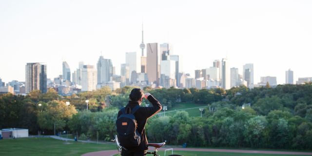 A person looks at the Toronto skyline from Riverdale Park in Toronto's east end