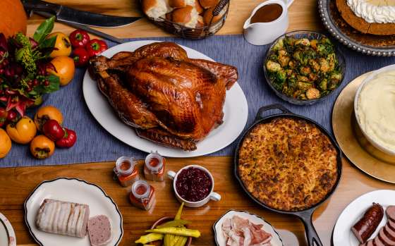 A Thanksgiving feast on wooden table including turkey and sides
