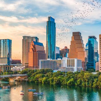 bats flying from the congress bridge in front of Austin skyline at sunset