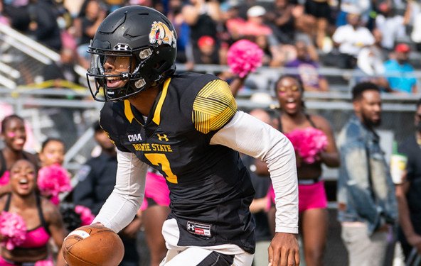 A Bowie State football player runs with the ball in a game