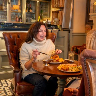 Two ladies enjoy a roast dinner in front of a real fire.