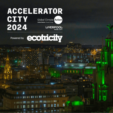An image of the Royal Liver Building lit up green with a view overlooking the city of Liverpool.